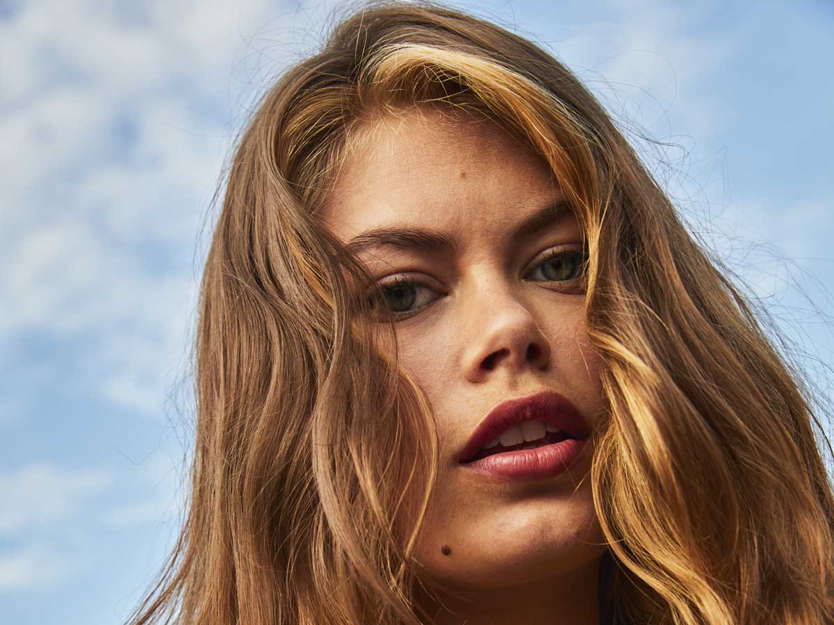 Een vrouw met blond haar op een blauwe achtergrond